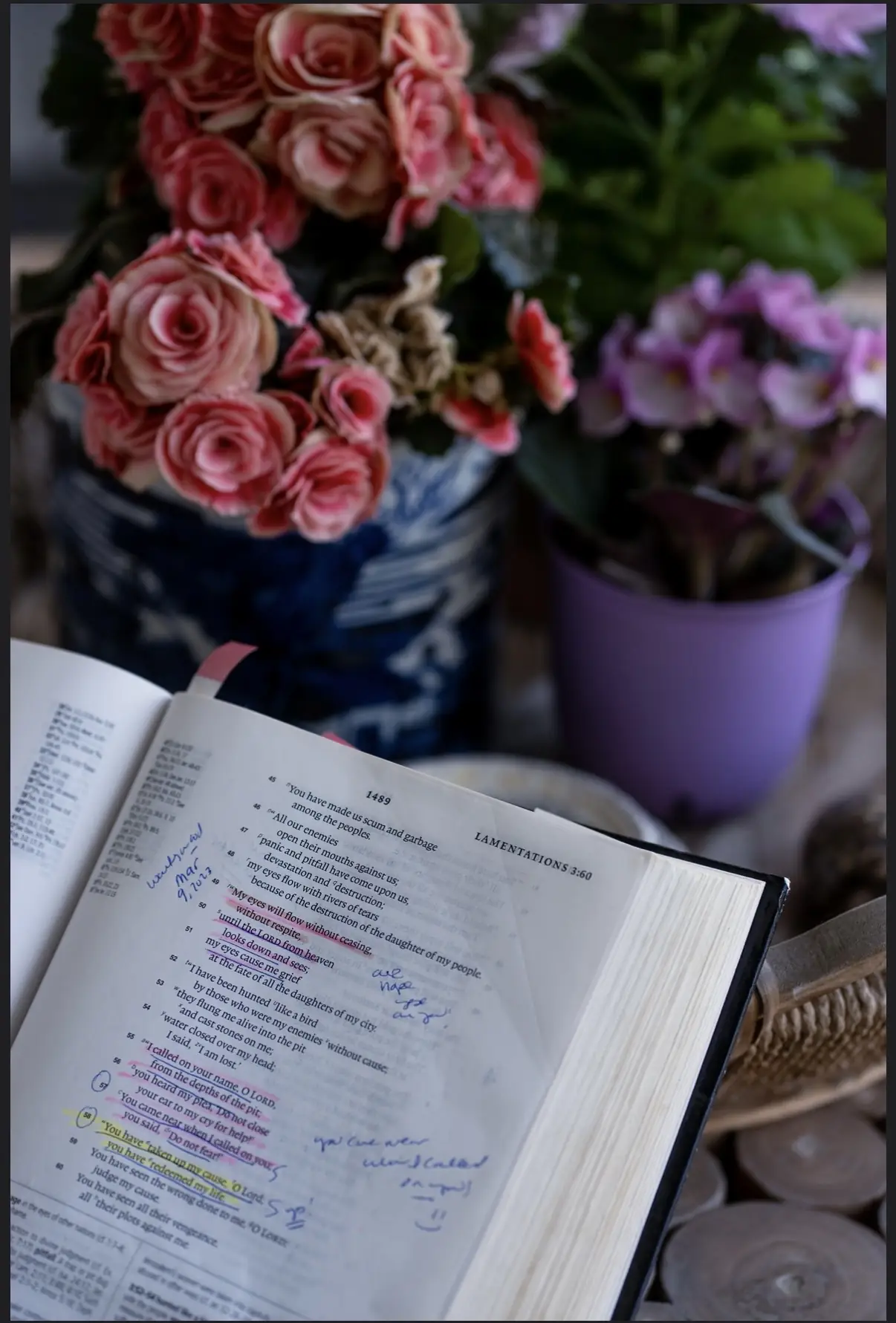 An open Bible with handwritten notes and flowers
